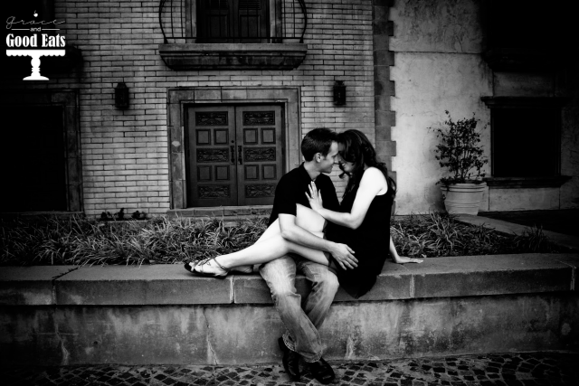 couple sitting on the ledge with her legs across his