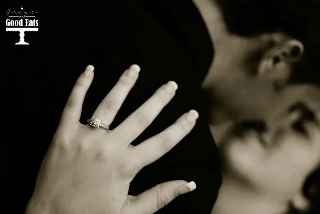 close up of engagement ring as man dips woman for a kiss