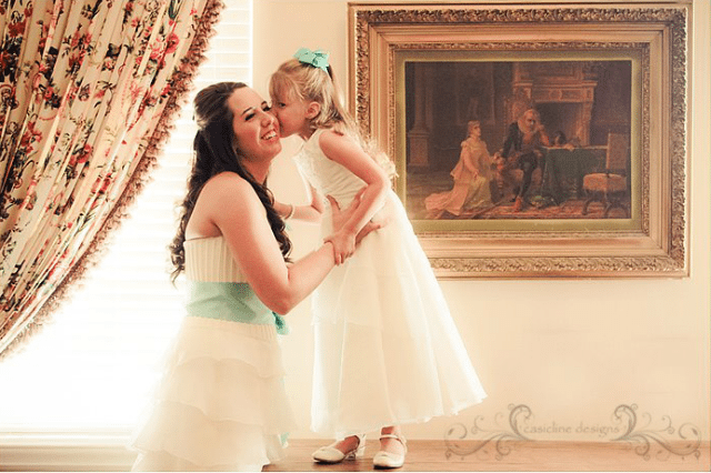 flowergirl kissing bride on the cheek