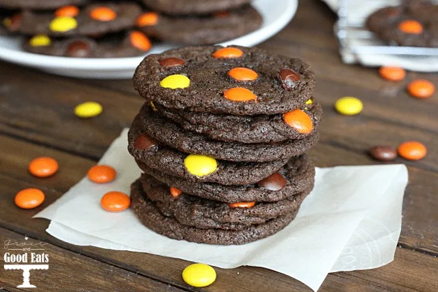stack of reese's pieces cookies on a piece of parchment paper 