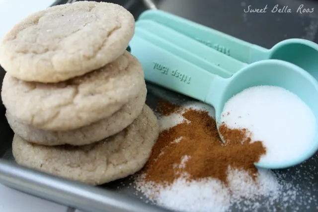 stack of three cinnamon sugar cookies next to cinnamon-sugar mixture and measuring spoons 