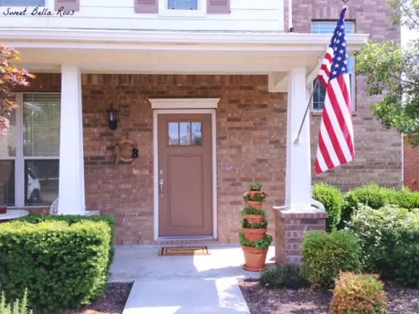 front porch with American flag and vertical planter