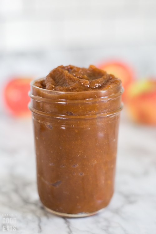 pumpkin apple butter in a jar with apples in the background
