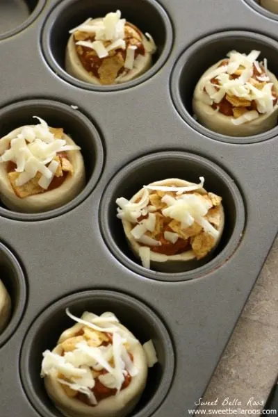 Warm chili, corn chips, sharp cheddar cheese all inside a flaky crescent roll cup make for the most delicious mini Frito Pies ever.