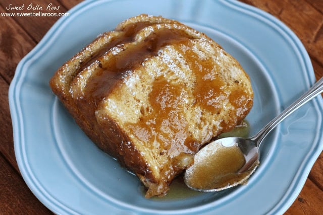 Three slices of overnight french toast bake on a blue plate with a spoon. 