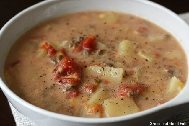 bowl of crockpot cheeseburger soup with chunks of potatoes, ground beef, and diced tomatoes