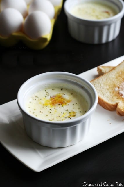 baked egg in ramekin on a plate with buttered toast