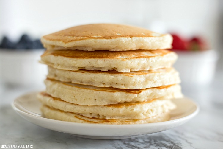 a stack of fluffy pancakes without syrup or toppings on a white plate