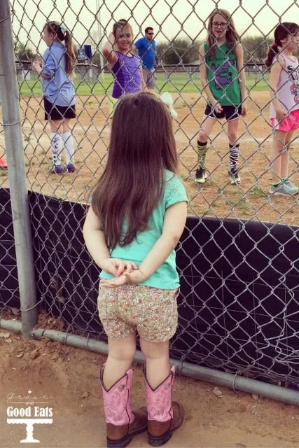 little sister watching big sister play sports