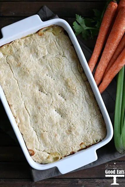 overhead view of a chicken pot pie with pie crust in a white baking dish. 