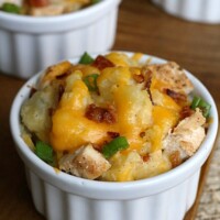 white dish with potatoes topped with melted cheese