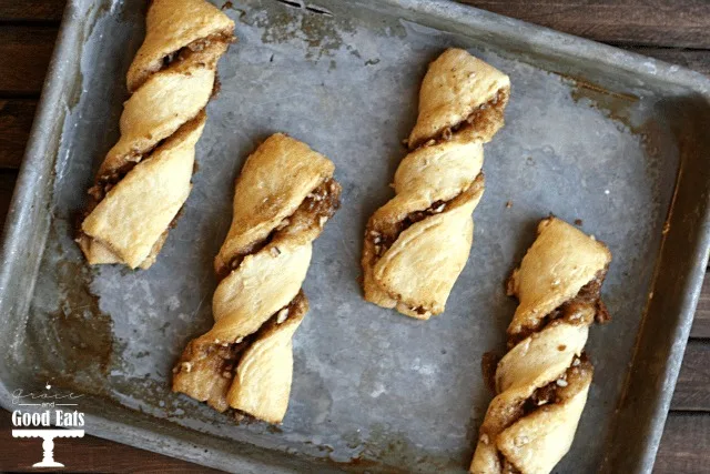 four baked cinnamon twists on a baking tray