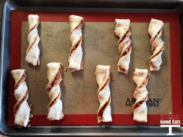 unbaked homemade cinnamon twists on a silpat-lined baking tray