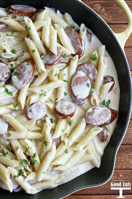 overhead view of smoked sausage alfredo in a cast iron skillet 