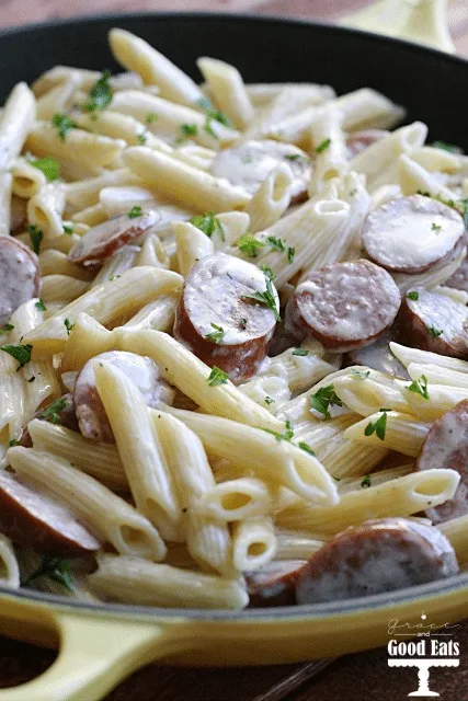 cast iron skillet full of smoked sausage alfredo pasta