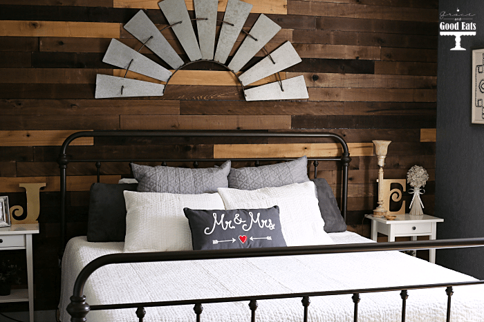 Bedroom inspiration! Love this DIY pallet wall, creamy white bedding, and iron bed!