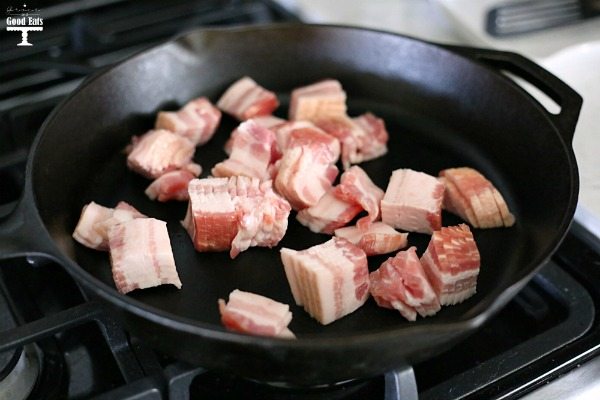 diced bacon frying in a cast iron skillet