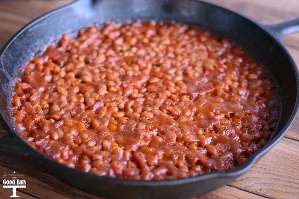 cast iron skillet full of baked beans with bacon