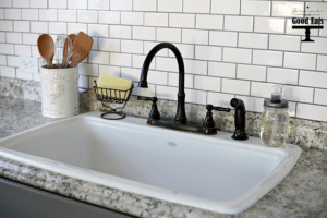 Love the way this farmhouse kitchen space turned out! Added subway tile, an open sink, and a new faucet to achieve that farmhouse look