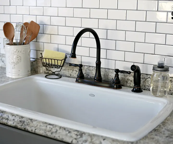 Love the way this farmhouse kitchen space turned out! Added subway tile, an open sink, and a new faucet to achieve that farmhouse look