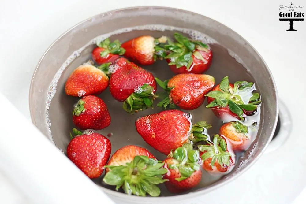 fresh strawberries sitting in pan of produce wash