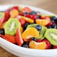 This fruit salad with honey lime dressing is the only recipe you need for all of your summer celebrations! It is my go-to recipe when I need to bring something to a BBQ or picnic. Fresh, colorful berries paired perfectly with a honey lime glaze you will want to eat with a spoon.