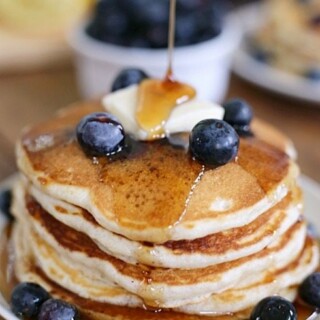 Stack of pancakes with syrup cascading down the sides