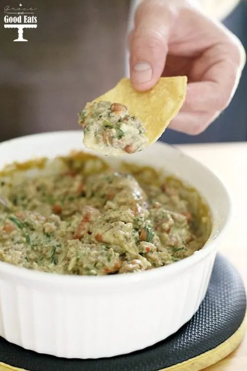 This Sausage and Bean Spinach Dip is a hearty appetizer full of spicy pork sausage and pinto beans. Serve warm for a delicious creamy dip with corn chips, pretzel rods, or bell pepper strips.