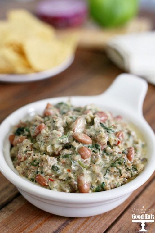 This Spinach, Sausage, and Bean Dip is a hearty appetizer full of spicy pork sausage and pinto beans. Serve warm for a delicious creamy dip with corn chips, pretzel rods, or bell pepper strips.