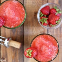 bowl of strawberries and drinks next to a wine cork