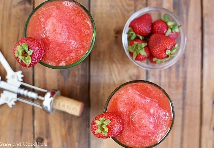 bowl of strawberries and drinks next to a wine cork