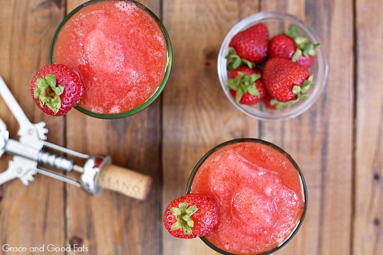 bowl of strawberries and frozen rose next to a wine cork