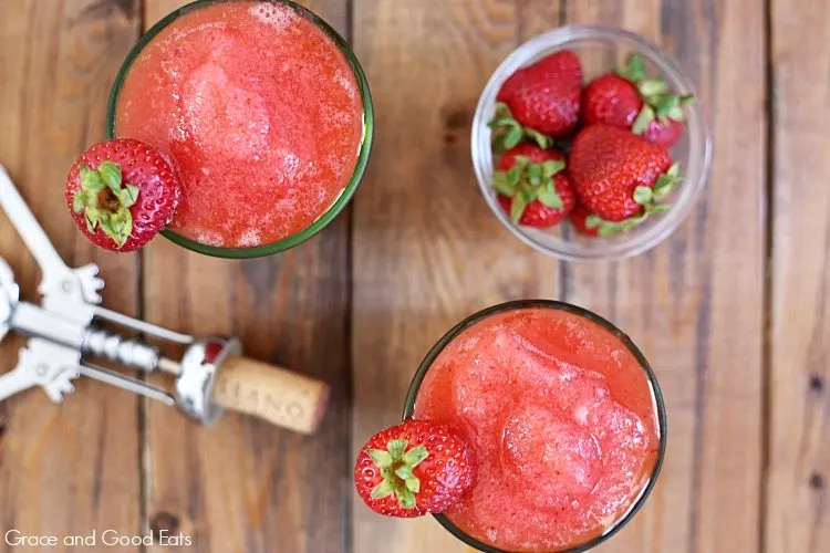 bowl of strawberries and frozen rose next to a wine cork