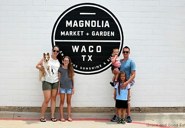 family in front of a Magnolia sign