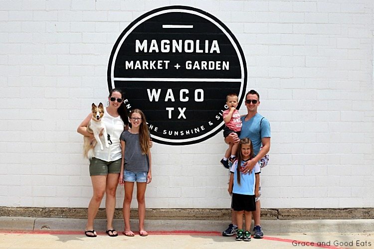family in front of a Magnolia sign