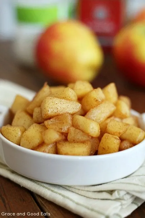 dish of cinnamon sauteed apples with apples in the background