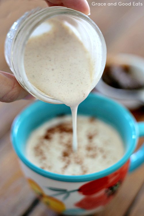 pouring spiced cream into a chai tea latte