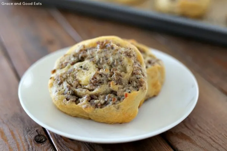 two sausage cream cheese pinwheels on a white plate 