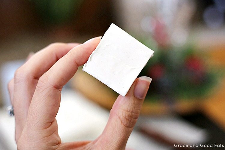 woman's hand holding up a piece of divinity fudge 