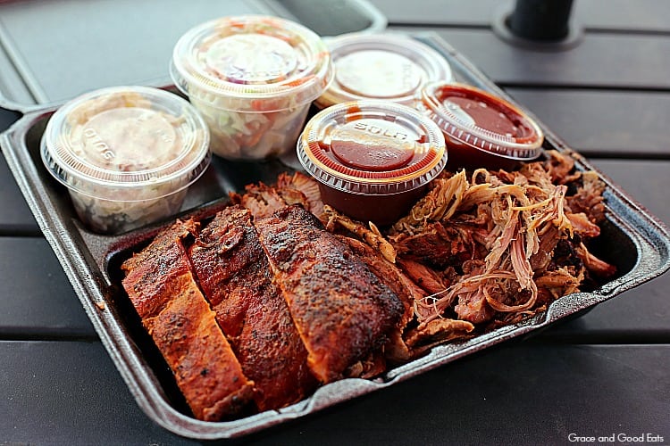 plate of BBQ meat in a black to-go container with sides