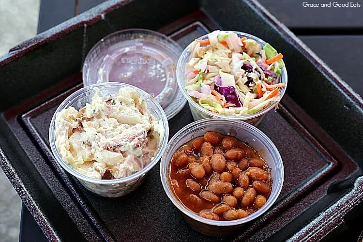 small, clear plastic containers of potato salad, coleslaw, and baked beans