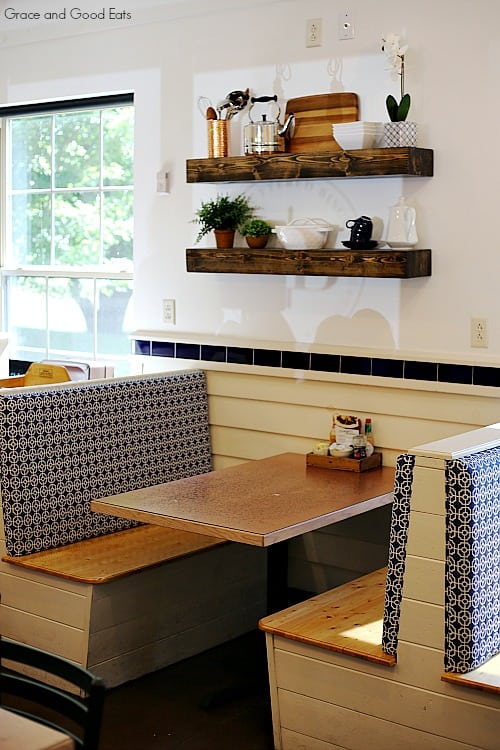 booth with wooden top table under wooden shelves with rustic decor