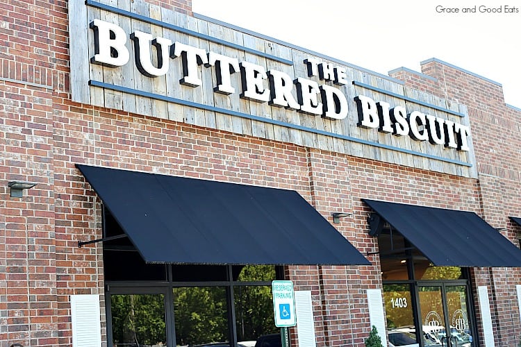 Brick front building with black awnings of The Buttered Biscuit