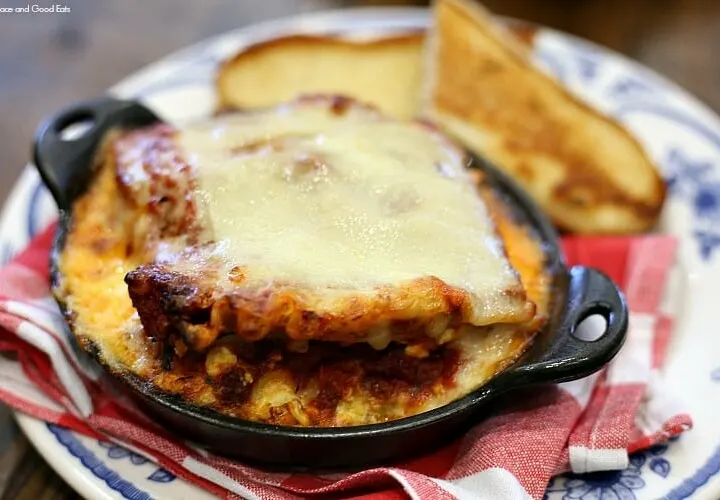 lasagna topped with cheese in a cast iron skillet