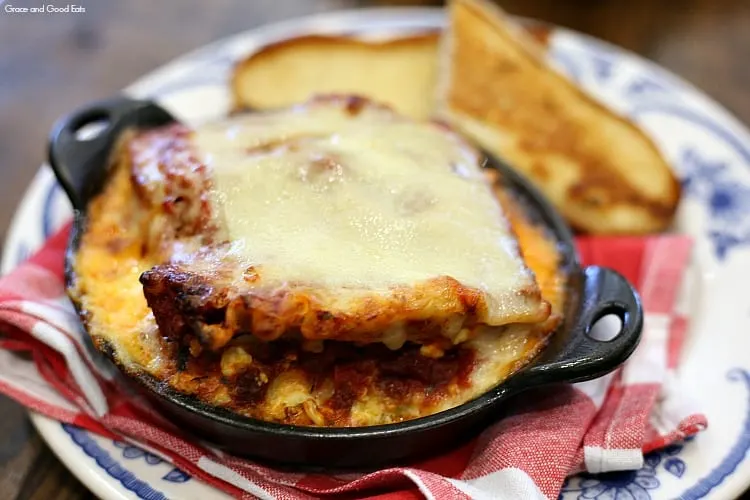 lasagna topped with cheese in a cast iron skillet