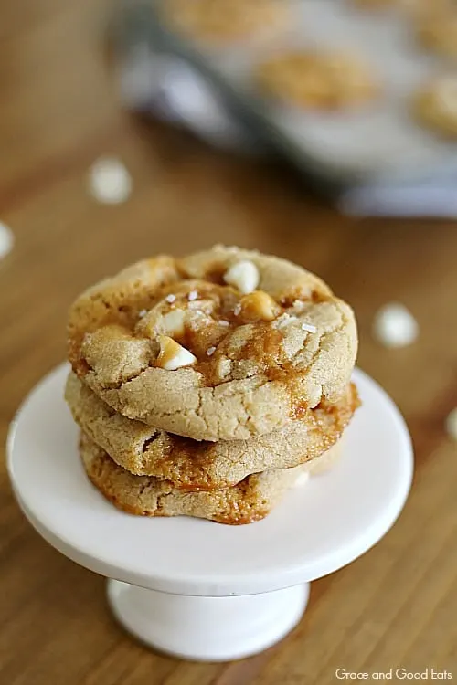 three salted caramel cookies stacked on a miniature white pedestal