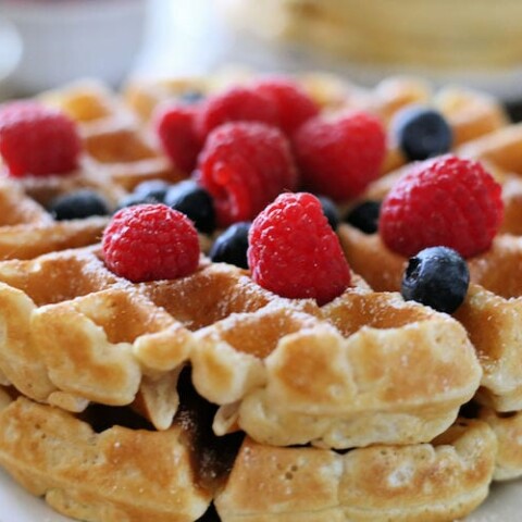 thick waffles topped with blueberries and raspberries