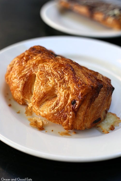 flaky croissant filled with ham and cheese on a white plate
