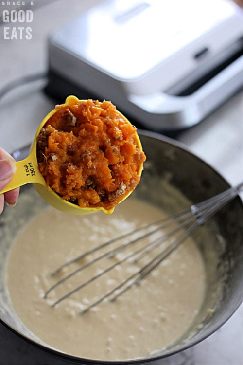 a scoop of sweet potato casserole in a yellow measuring cup