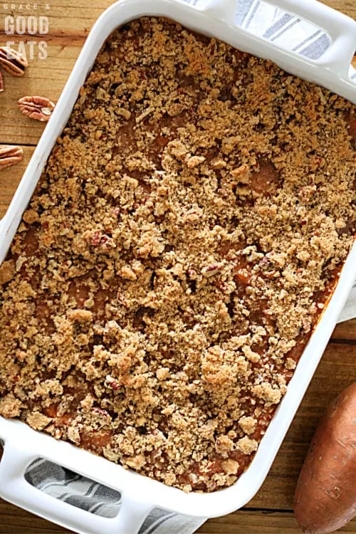 baked sweet potato casserole with pecan topping in a white dish